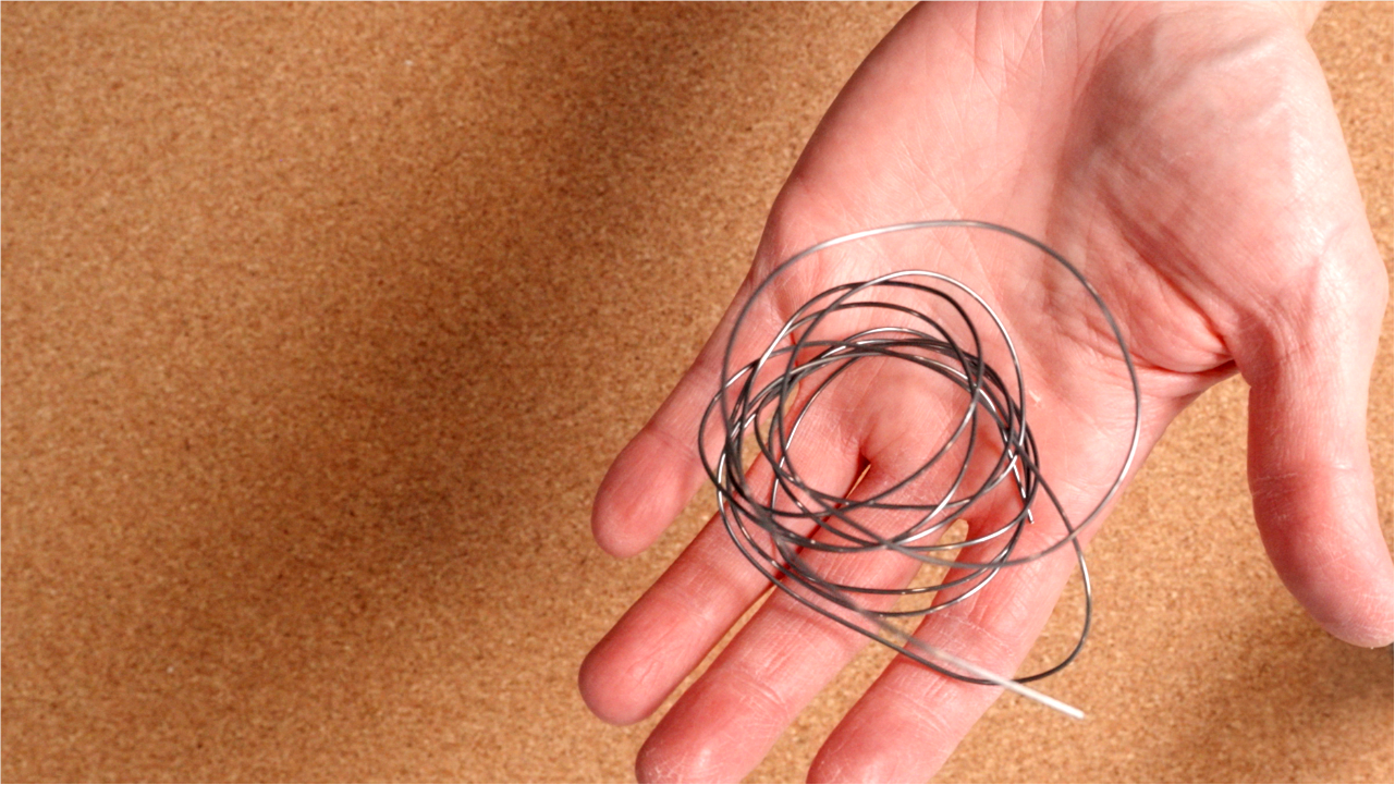 A hand holding a nitinol wire
