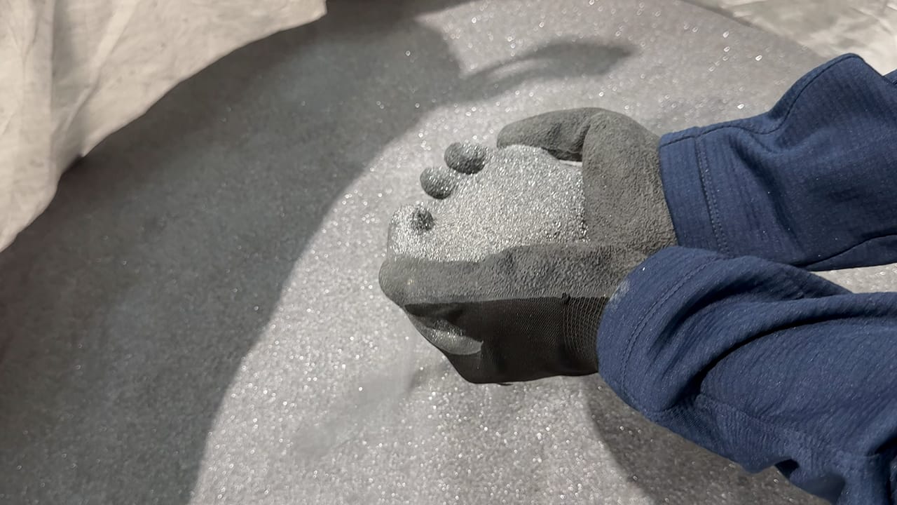 Gloved hands holding recycled solar panel dust