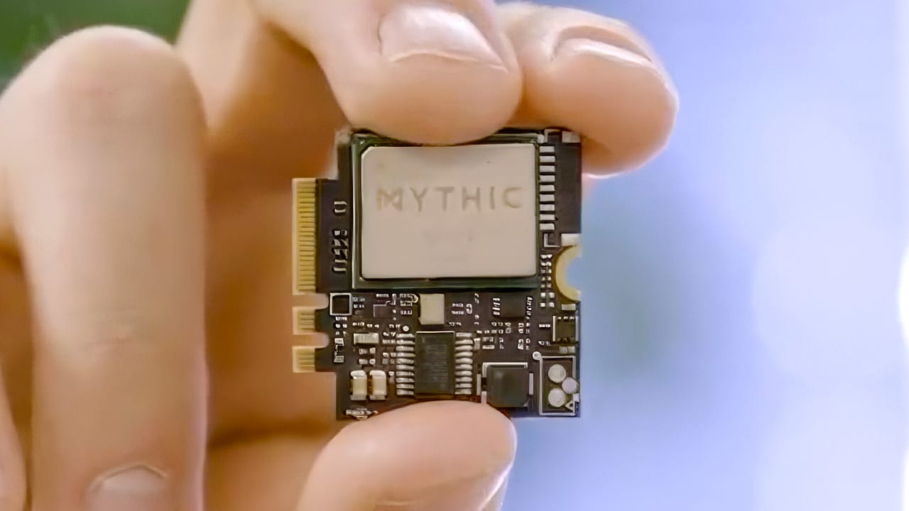 A hand holding a Mythic computer chip